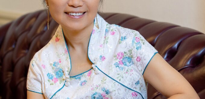 Smiling woman in floral cheongsam on sofa